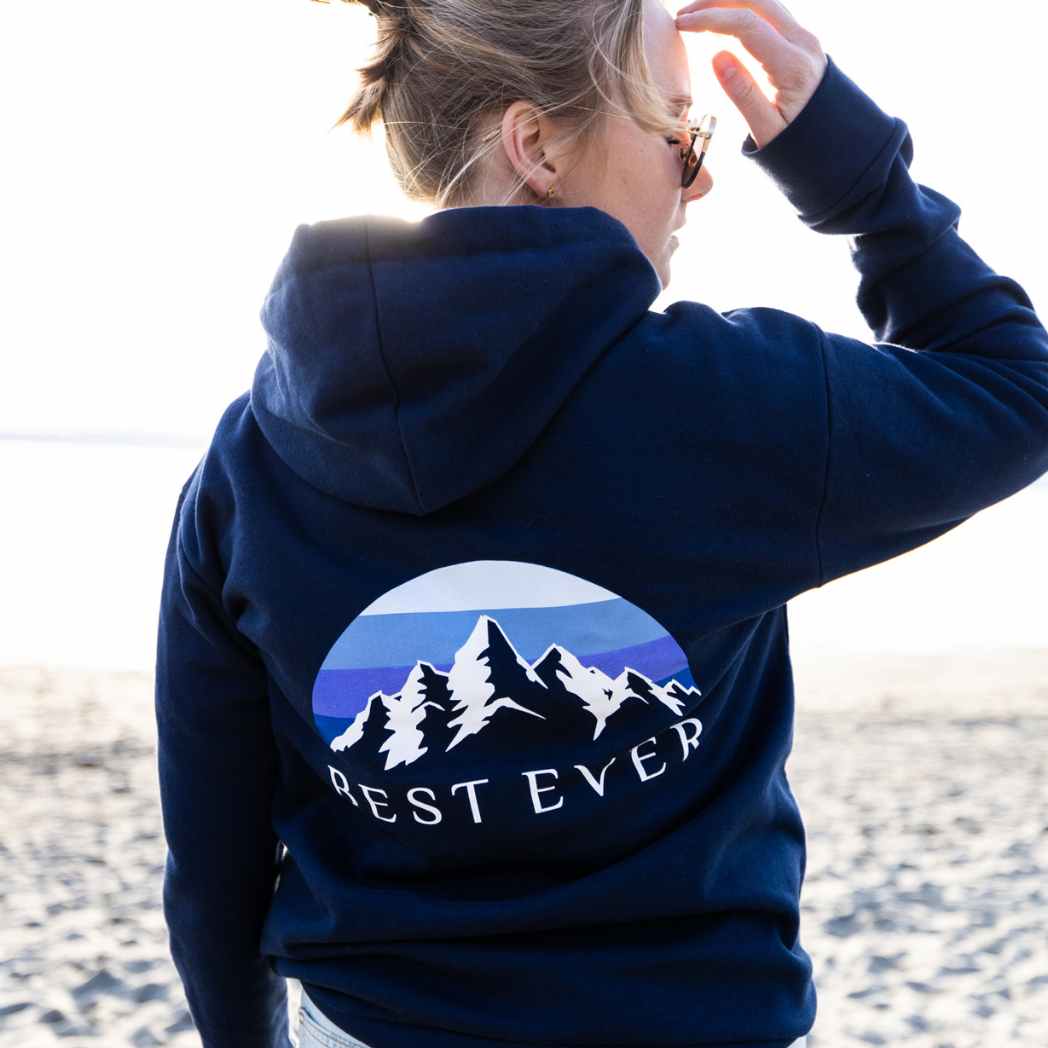 woman on beach wearing best ever mountain calling hoodie